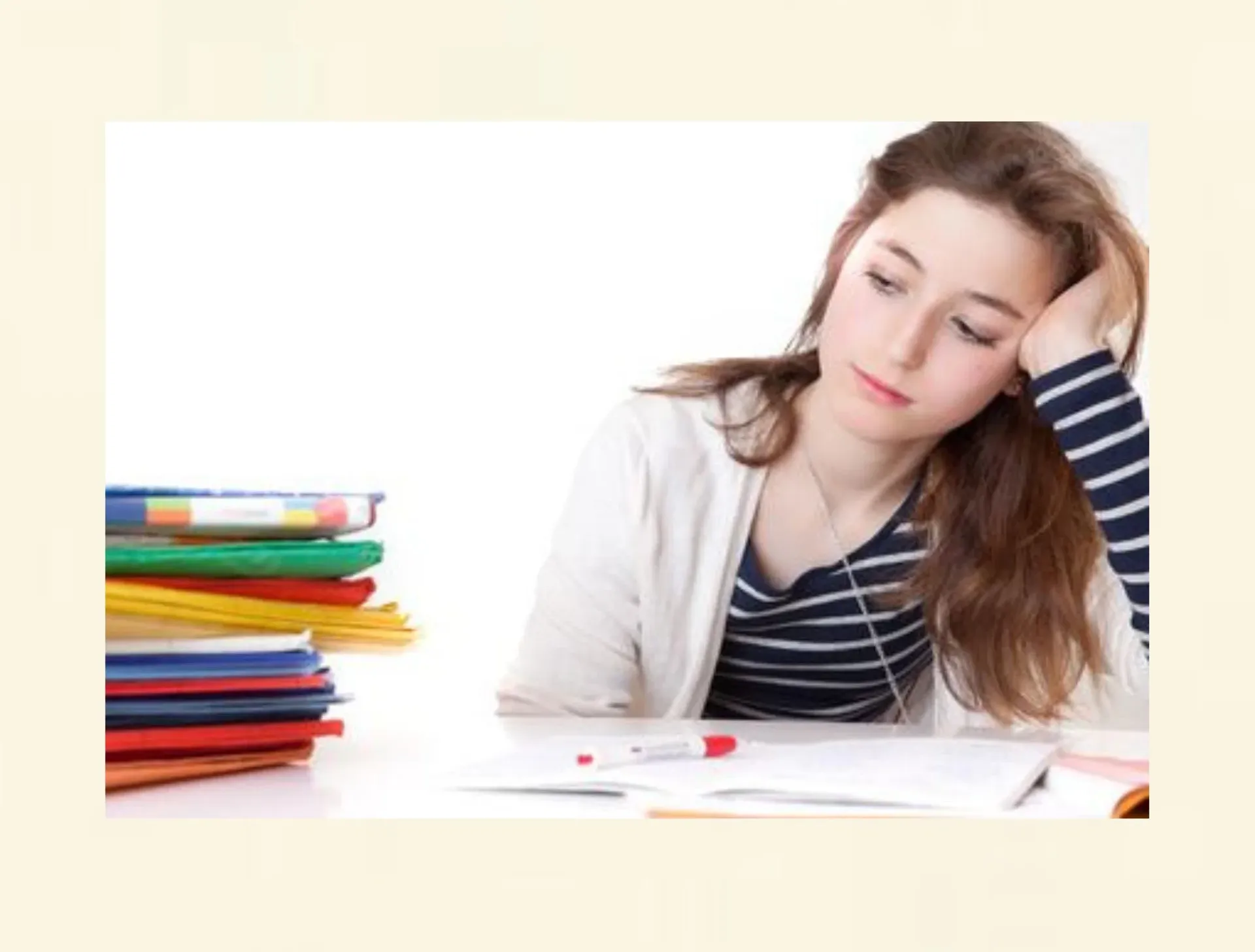 Schülerin wirkt müde und überfordert durch Prüfungsdruck beim Lernen