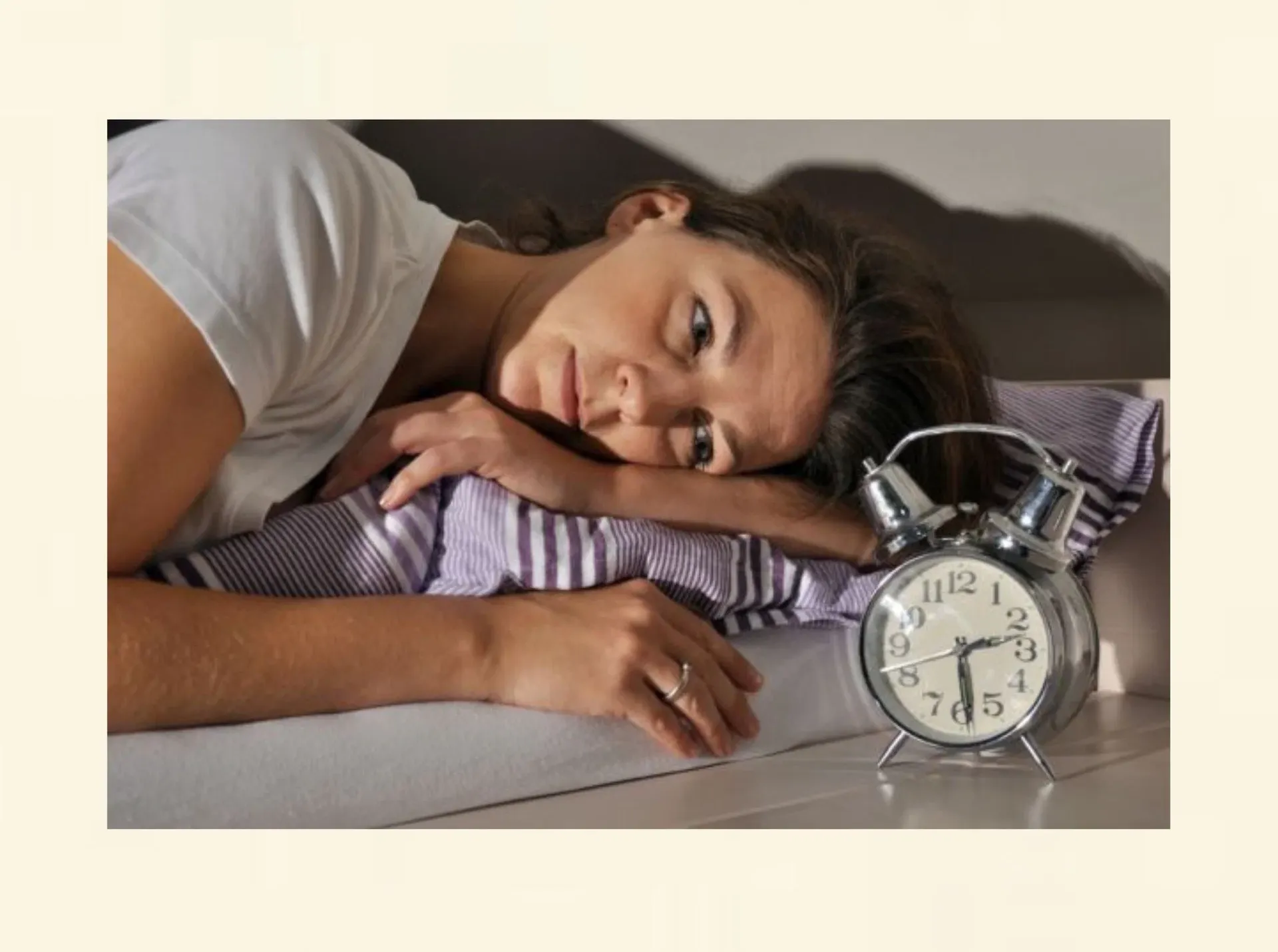 Frau liegt wach im Bett als Symbol für Schlafstörungen