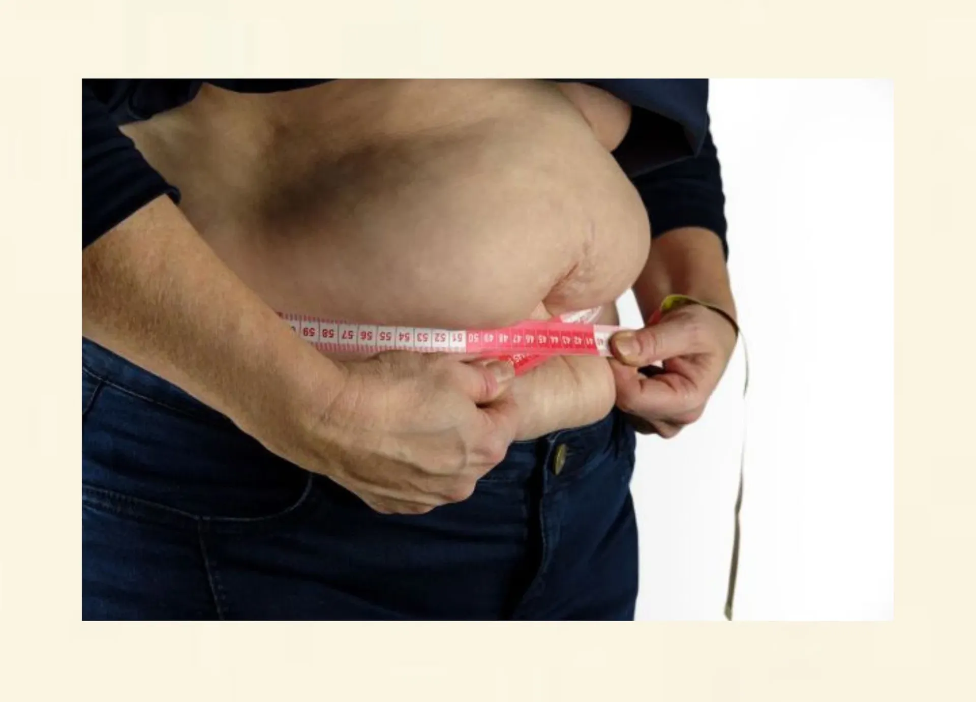Übergewichtige Person misst den Körperumfang mit einem Massband – Symbol für Gewichtszunahme