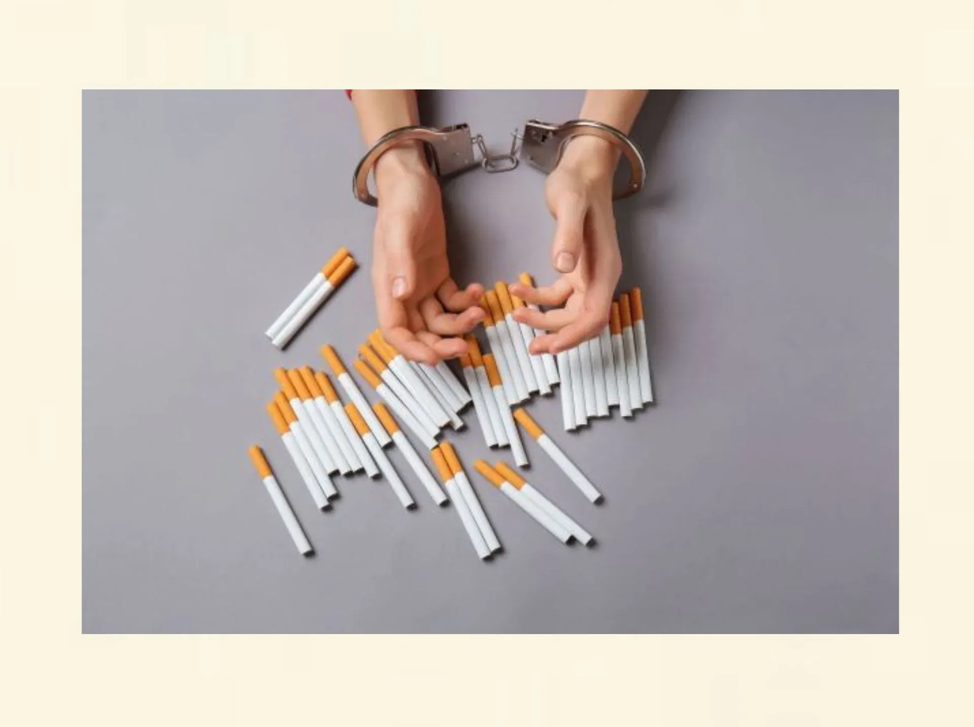 Hände in Handschellen mit Zigaretten als Symbol für Nikotinsucht und den Weg zum Nichtraucher