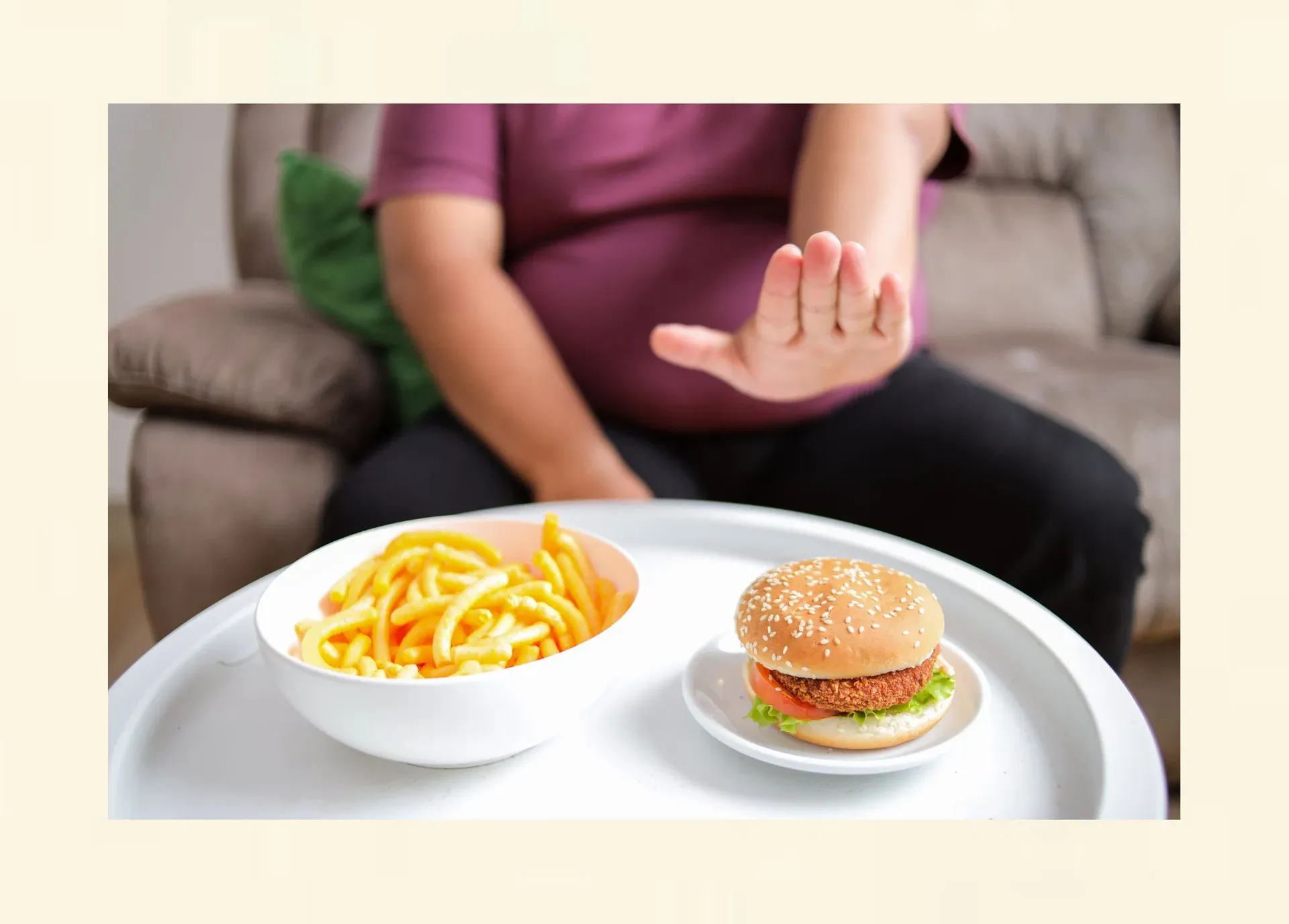 Person lehnt einen Hamburger ab – innere Kontrolle während einer Diät