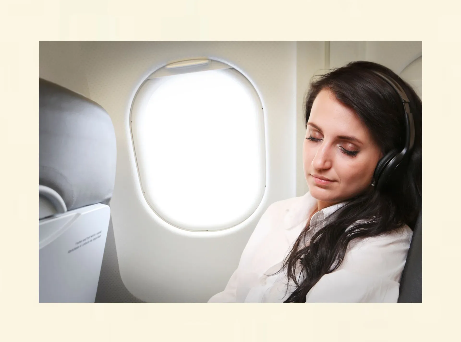 Entspannte Frau sitzt im Flugzeug und hört Musik – möglicher neuer Umgang mit Flugangst